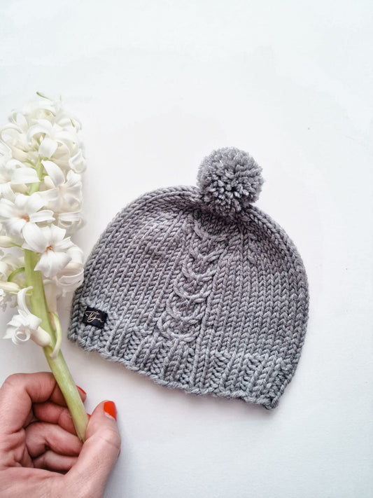 Newborn hat with a cable and pompom