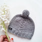 Newborn hat with a cable and pompom